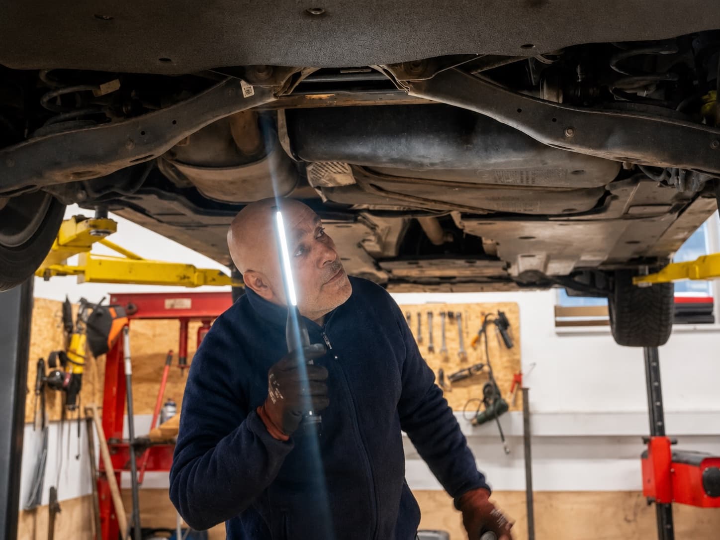 Mekaniker arbejder under en bil hos Super Auto i Hillerød