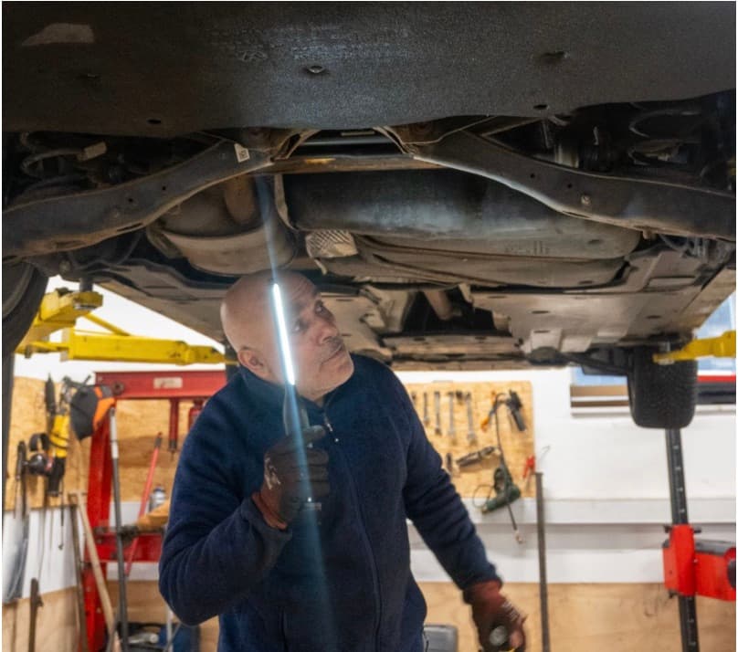 Mekaniker arbejder under en bil ved koblingsskift hos Super Auto i Hillerød